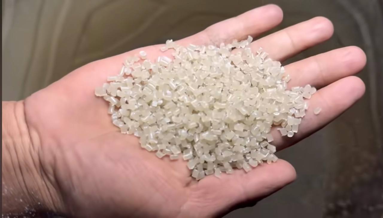 Handful of clean white recycled plastic pellets